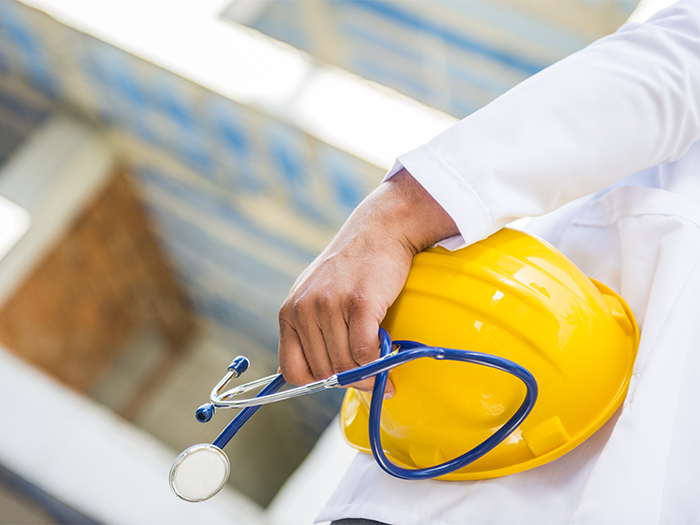 Doctor hand with stethoscope and yellow hard hat